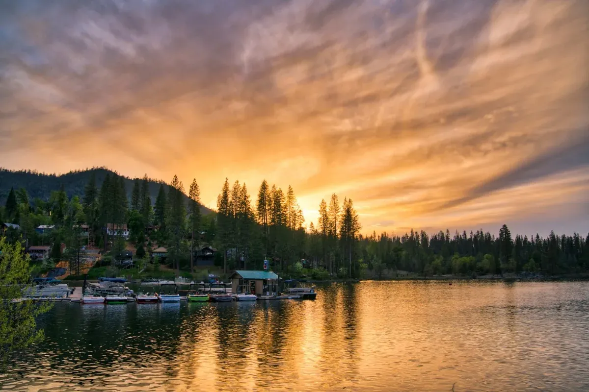 Sunset over Bass Lake, boats moored along the far shore under a burning sky